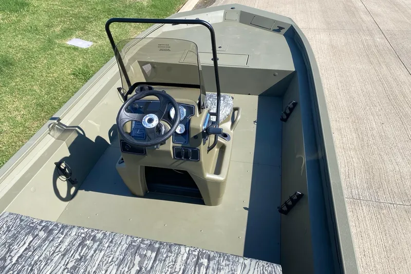 Slide: The Image of 2026 Tracker Grizzly 1860 CC boat interior with steering console and seating. - 6