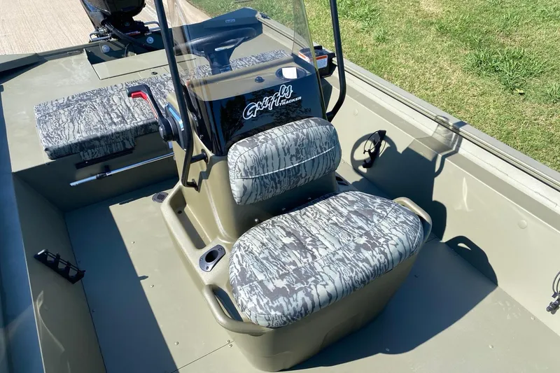 Slide: The Image of 2026 Tracker Grizzly 1860 CC boat interior with camo seats and steering console. - 9