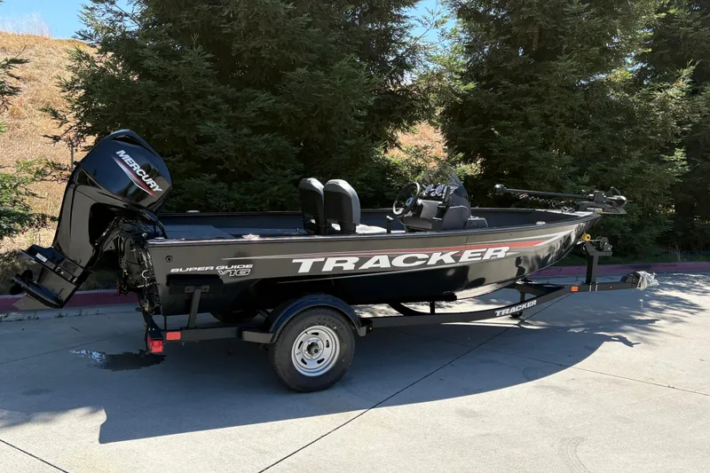 Slide: The Image of 2026 Tracker Super Guide V-16 SC boat on trailer, parked outdoors. - 2