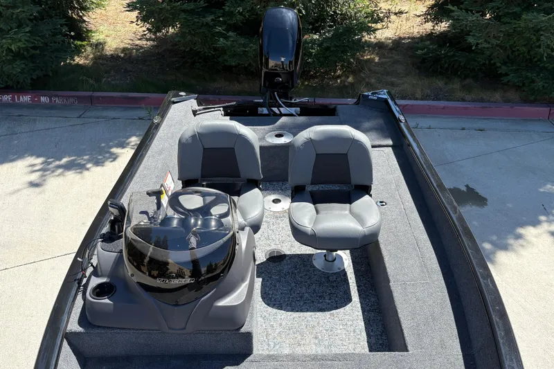 Slide: The Image of 2026 Tracker Super Guide V-16 SC boat with dual seats and console, parked outdoors. - 16