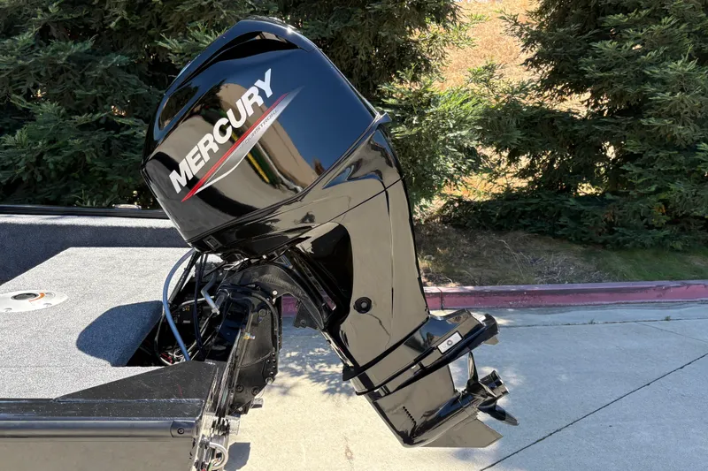 Slide: The Image of 2026 Tracker Super Guide V-16 SC with Mercury outboard motor, parked outdoors. - 12