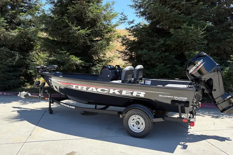 Slide: The Image of 2026 Tracker Super Guide V-16 SC boat with Mercury engine, parked outdoors. - 5
