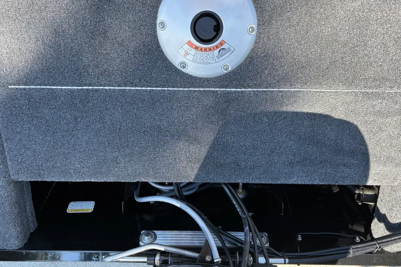 Slide: The Image of 2026 Tracker Super Guide V-16 SC boat interior with visible wiring and warning label. - 22