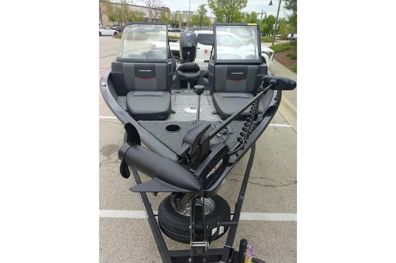Slide: The Image of 2026 Tracker Pro Guide V-175 Combo boat with dual windshields and trolling motor in parking lot. - 62