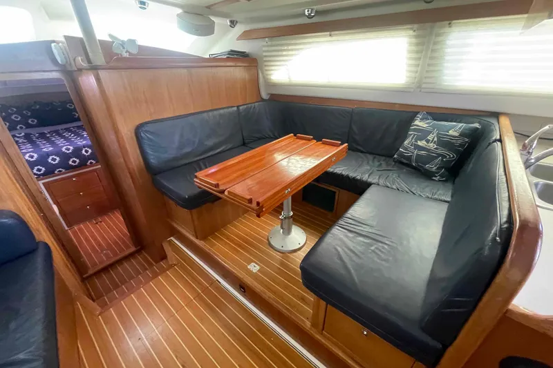 Slide: The Image of Luxurious 2013 Catalina Morgan 440 yacht interior with cozy seating and wooden table. - 13