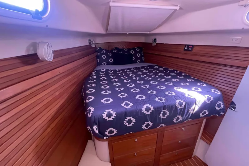 Slide: The Image of Cozy cabin interior of 2013 Catalina Morgan 440 with wooden paneling and patterned bedding. - 14