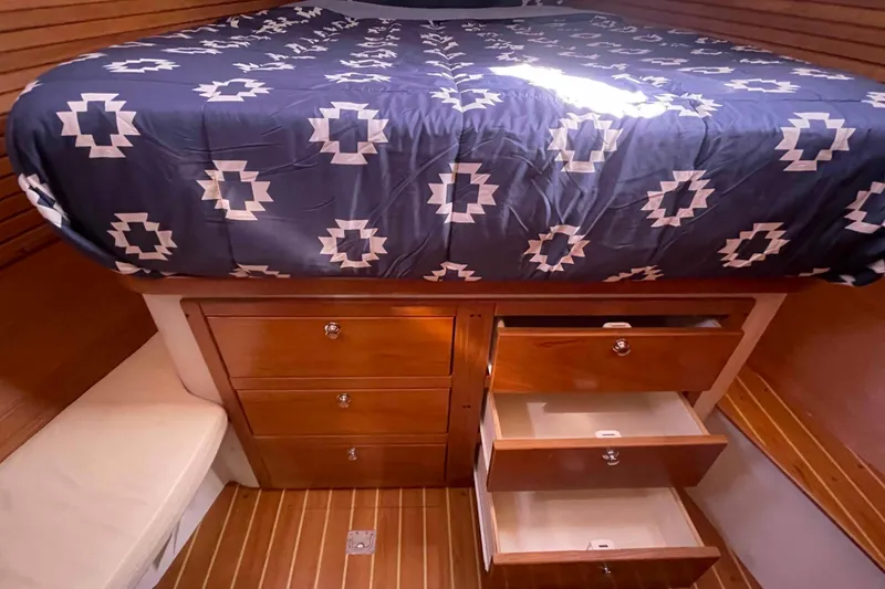 Slide: The Image of Cozy cabin interior of 2013 Catalina Morgan 440 with patterned bedding and wooden storage drawers. - 15