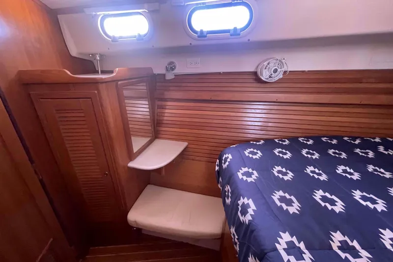 Slide: The Image of Cozy cabin interior of 2013 Catalina Morgan 440 sailboat with wooden paneling and patterned bedding. - 16