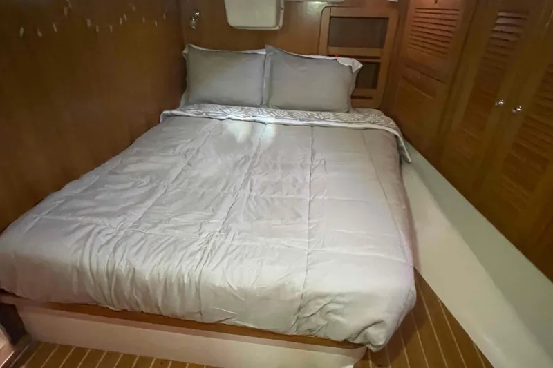 Slide: The Image of Cozy bedroom interior of 2013 Catalina Morgan 440 yacht with wooden accents and comfortable bedding. - 21