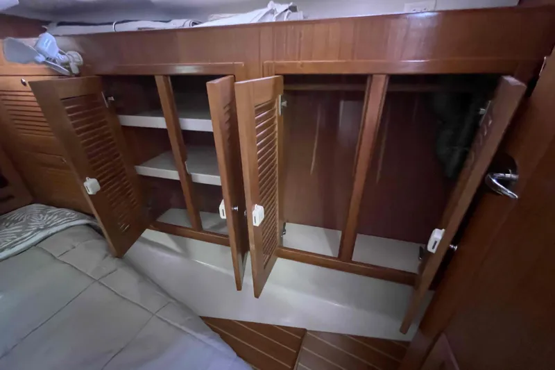 Slide: The Image of Wooden cabinets with open doors inside a 2013 Catalina Morgan 440 yacht cabin. - 23