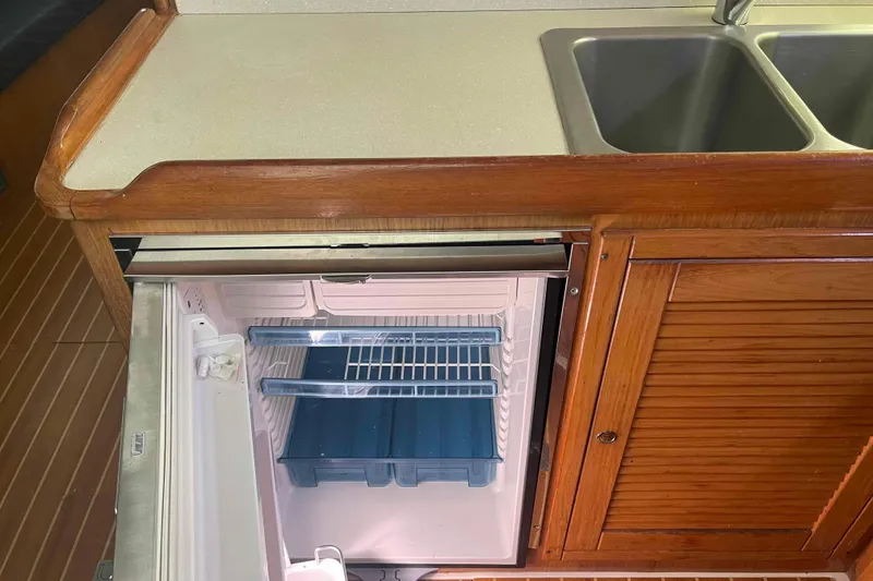 Slide: The Image of 2013 Catalina Morgan 440 yacht kitchen with open fridge and double sink. - 38