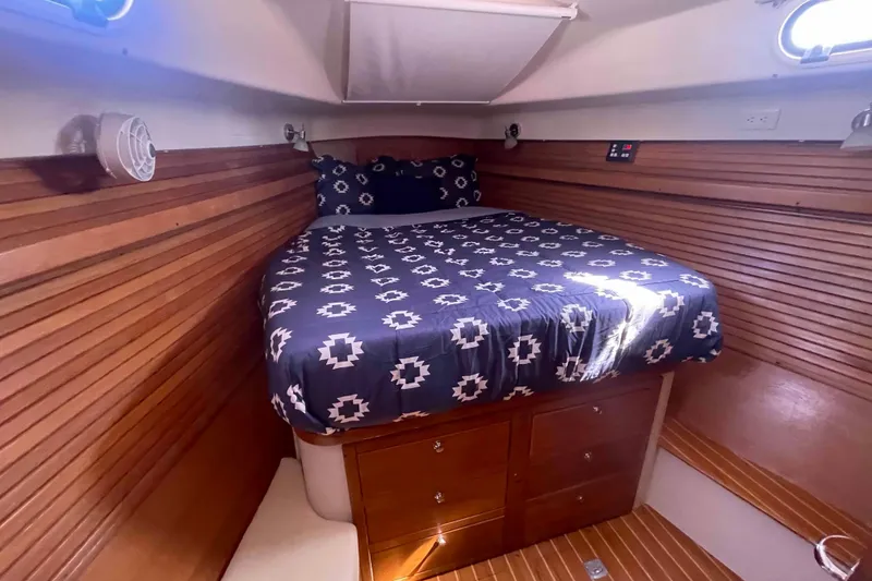 Slide: The Image of Cozy cabin interior of 2013 Catalina Morgan 440 sailboat with patterned bedding. - 6