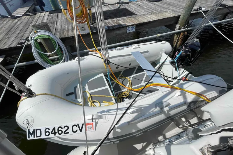 Slide: The Image of Inflatable dinghy docked beside a Catalina Morgan 440 sailboat, with ropes and equipment visible. - 63