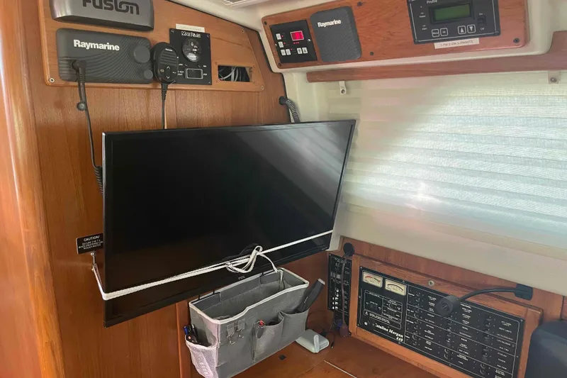 Slide: The Image of Interior of a 2013 Catalina Morgan 440 yacht with navigation equipment and a mounted TV. - 64