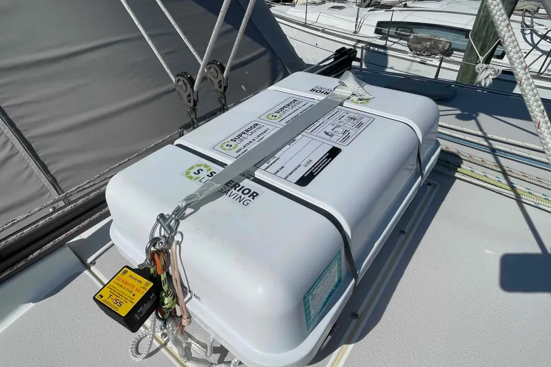 Slide: The Image of Life raft on 2013 Catalina Morgan 440 sailboat deck, secured with straps and safety equipment. - 70