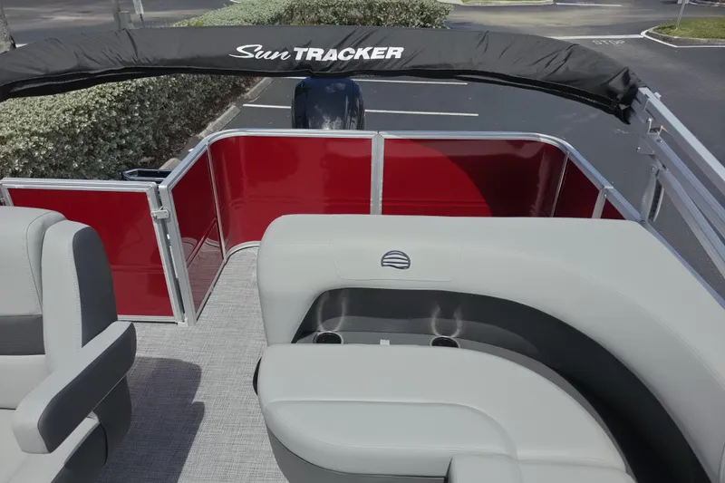 Slide: The Image of 2026 Sun Tracker Party Barge 18 DLX interior with gray seating and red paneling. - 10