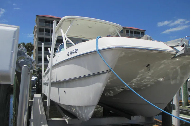 Slide: The Image of 2020 World Cat 230 SD boat docked with blue rope, under a clear sky. - 1
