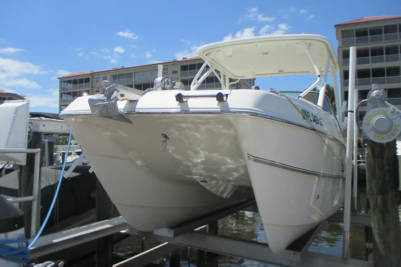 Slide: The Image of 2020 World Cat 230 SD boat docked at marina with buildings in background. - 3