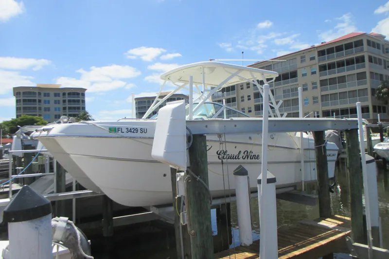 Slide: The Image of 2020 World Cat 230 SD boat docked at marina with buildings in background. - 5