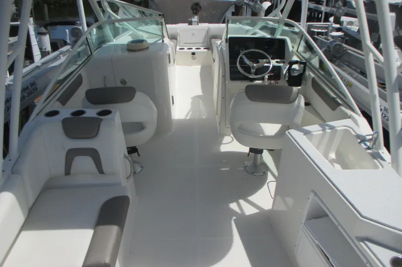 Slide: The Image of 2020 World Cat 230 SD boat docked, covered with a gray tarp. - 6
