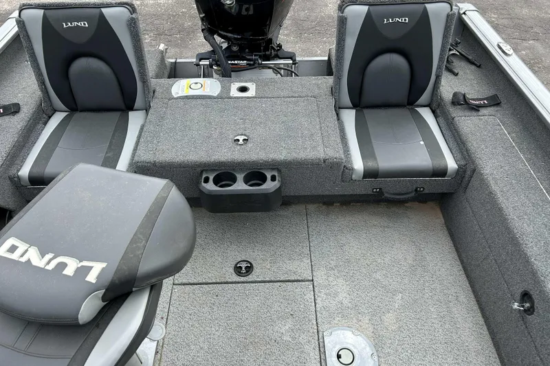 Slide: The Image of 2025 Lund 1875 Impact XS Sport boat interior with gray seating and storage compartments. - 10