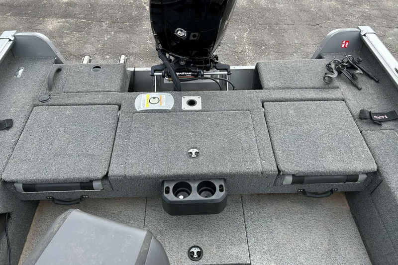 Slide: The Image of 2025 Lund 1875 Impact XS Sport boat interior with carpeted deck and motor. - 11