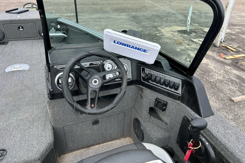 Slide: The Image of 2025 Lund 1875 Impact XS Sport boat dashboard with Lowrance electronics and steering wheel. - 7