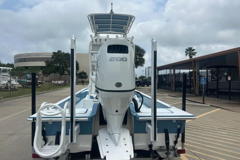 Slide: The Image of 2026 Shallow Sport 22 Sport boat with powerful outboard motor, parked near university campus. - 2