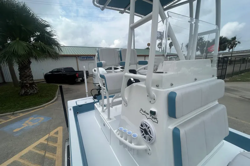 Slide: The Image of 2026 Shallow Sport 22 Sport boat with elevated seating and sleek design in a parking lot. - 9