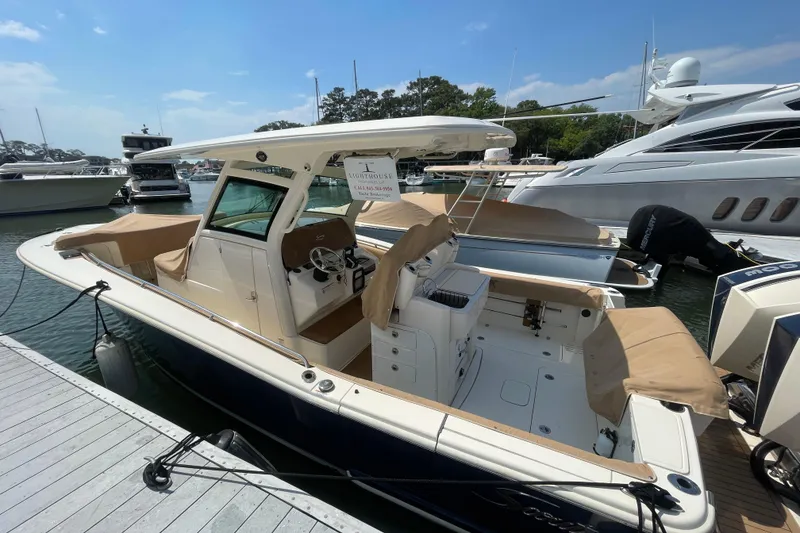The Image of 2023 Scout 305 LXF boat docked at marina, featuring sleek design and spacious seating. - 0