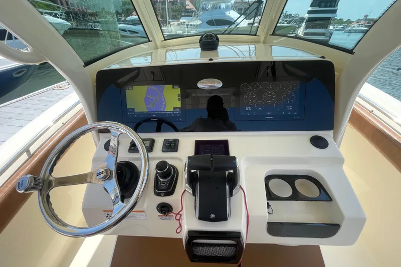 Slide: The Image of 2023 Scout 305 LXF boat helm with steering wheel and navigation display. - 11