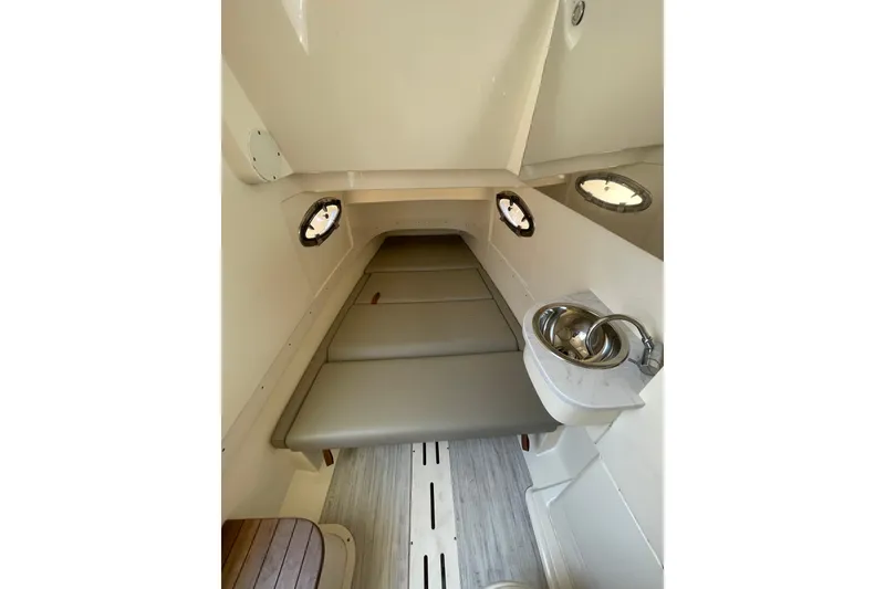 Slide: The Image of 2023 Scout 305 LXF cabin interior with cushioned seating and compact sink. - 25