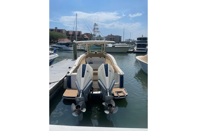 Slide: The Image of 2023 Scout 305 LXF boat docked at marina with twin engines. - 3