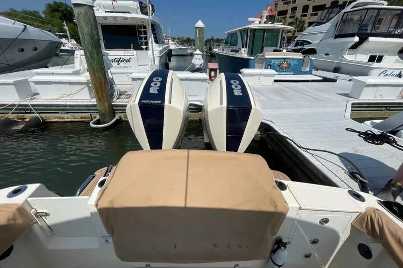 Slide: The Image of 2023 Scout 305 LXF boat with dual Mercury 300 engines docked at marina. - 4