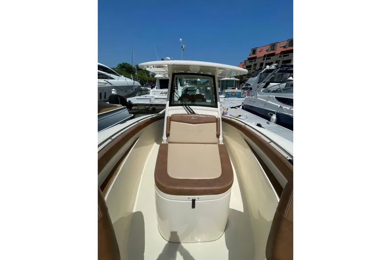 Slide: The Image of 2023 Scout 305 LXF boat interior with seating, docked at marina. - 6