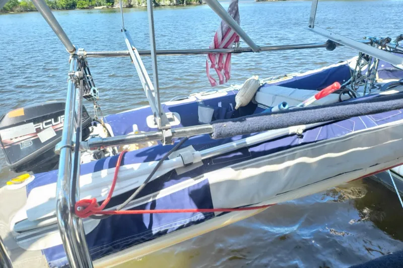 Slide: The Image of 1993 Hunter Legend 40.5 sailboat with dinghy and outboard motor on calm water. - 23