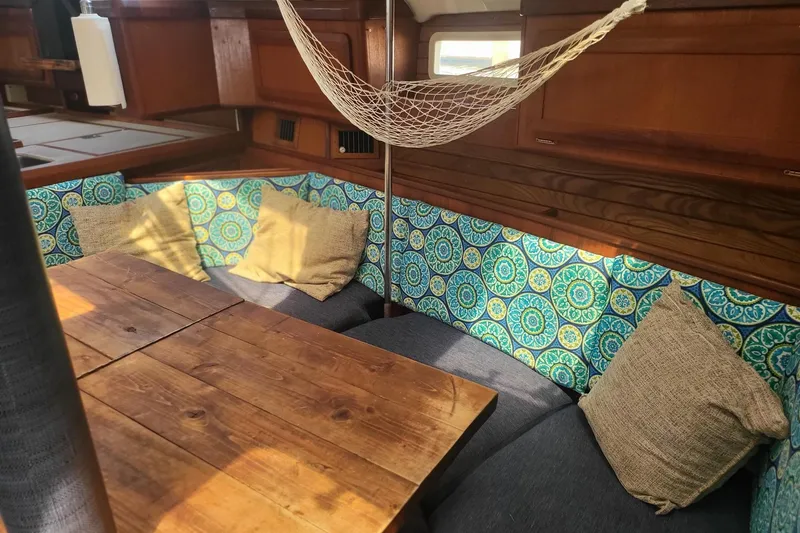 Slide: The Image of Interior of 1993 Hunter Legend 40.5 sailboat with colorful cushions and wooden table. - 9