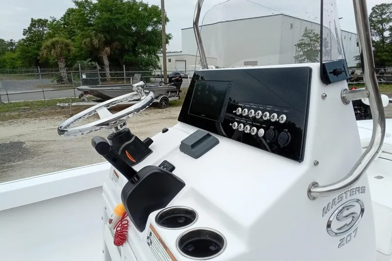 Slide: The Image of 2021 Sportsman Masters 207 Bay Boat dashboard with steering wheel and control panel. - 12