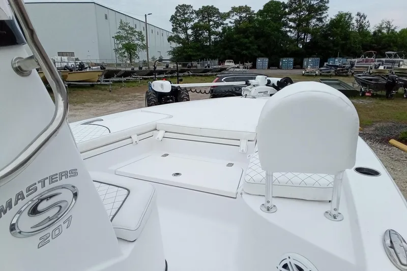 Slide: The Image of 2021 Sportsman Masters 207 Bay Boat with white seating and storage compartments. - 13