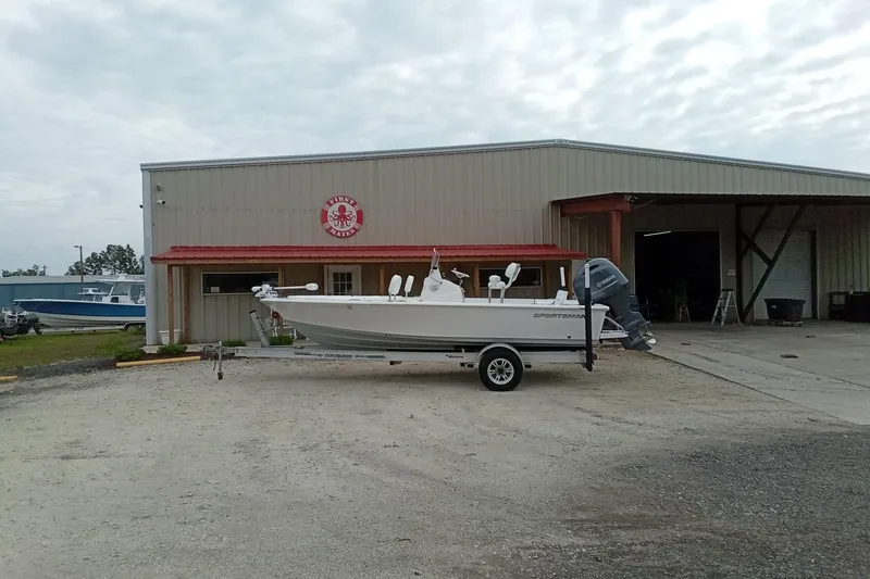 Slide: The Image of 2021 Sportsman Masters 207 Bay Boat on trailer outside a marine warehouse. - 2