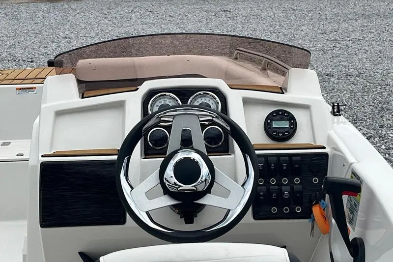 Slide: The Image of 2024 Starcraft SVX 191 OB boat dashboard with steering wheel and control panel. - 15