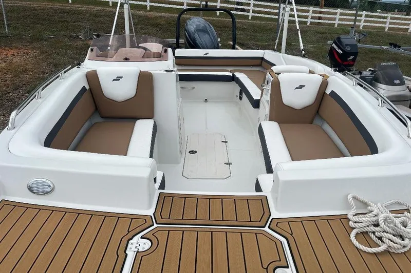 Slide: The Image of 2024 Starcraft SVX 191 OB boat interior with tan and white seating, wood-style flooring. - 17