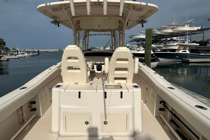 Slide: The Image of 2016 Grady-White Canyon 306 boat interior at marina, showcasing helm and seating. - 10