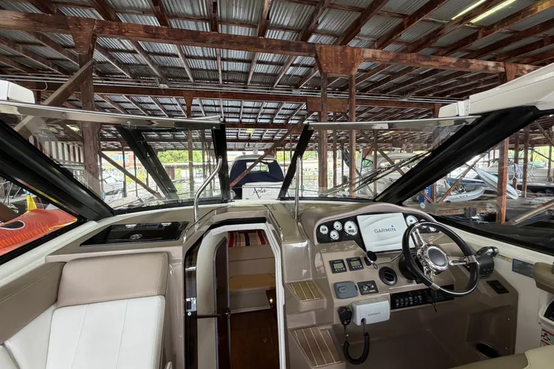 Slide: The Image of 2016 Regal 35 Sport Coupe interior with helm, steering wheel, and navigation equipment in a marina. - 10