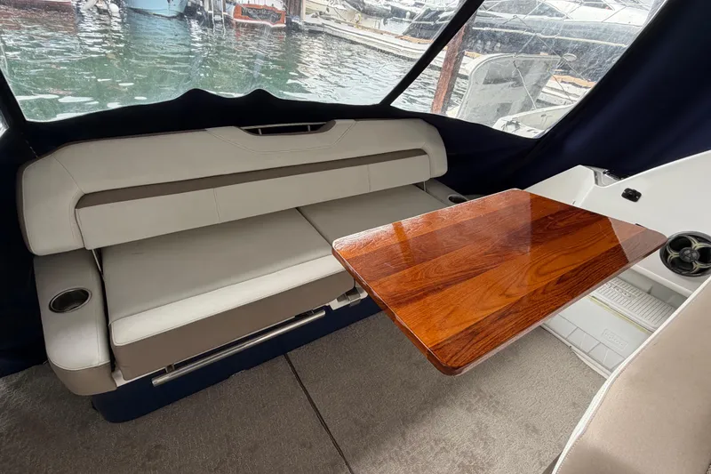 Slide: The Image of 2016 Regal 35 Sport Coupe interior with cushioned seating and polished wooden table. - 12