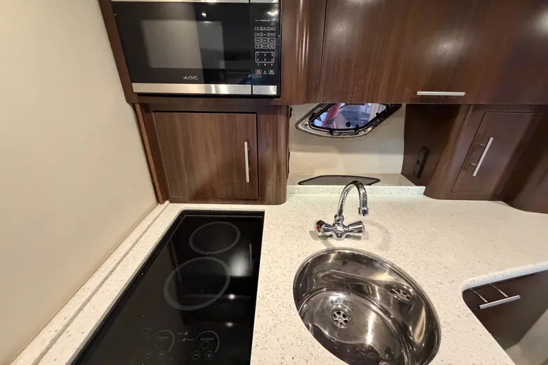 Slide: The Image of Modern kitchen in 2016 Regal 35 Sport Coupe with microwave, stovetop, and sink. - 29