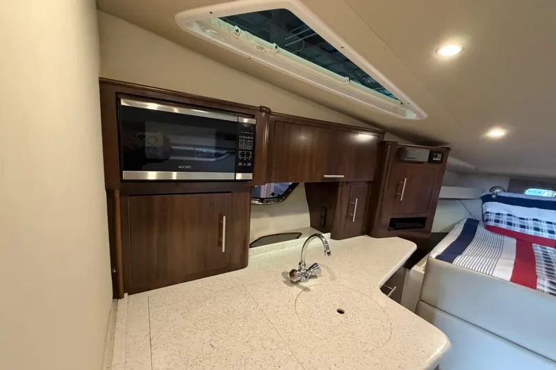 Slide: The Image of Interior of 2016 Regal 35 Sport Coupe featuring kitchenette and cozy sleeping area. - 30