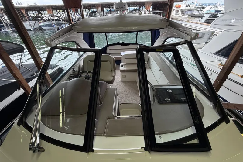 Slide: The Image of 2016 Regal 35 Sport Coupe boat interior at marina, showcasing seating and helm. - 4