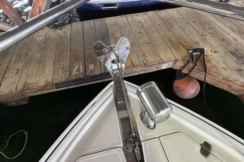 Slide: The Image of Bow of 2016 Regal 35 Sport Coupe docked, featuring anchor and wooden pier. - 7