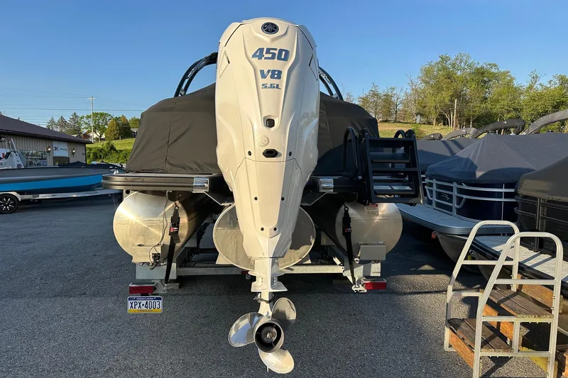 Slide: The Image of 2024 Bennington LX Sport Line boat with powerful 450 V8 engine, parked outdoors. - 2